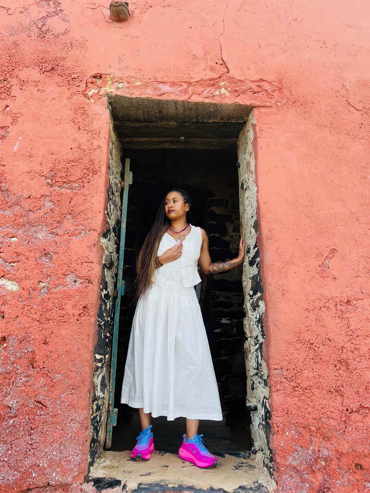 Dr. Sará King standing in the Door of No Return on Goree Island, Senegal — the last threshold many enslaved Africans crossed before being taken across the Atlantic.